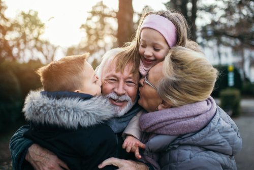 grandparents hugging their grandchildren