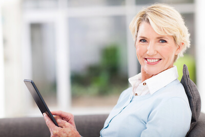Middle aged woman using tablet at home