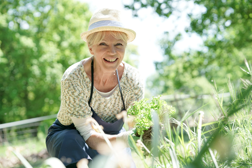 Older woman smiling in her garden after cataract surgery